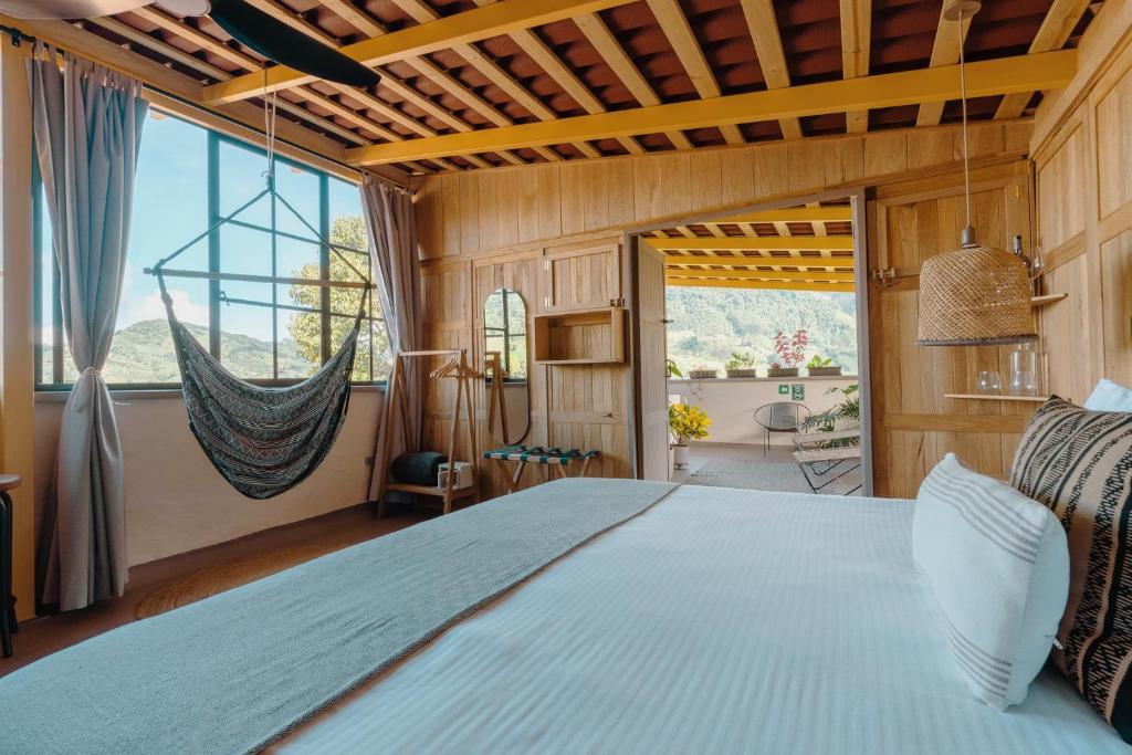 贾丁Hotel Plantación的一间卧室设有一张大床和一个大窗户