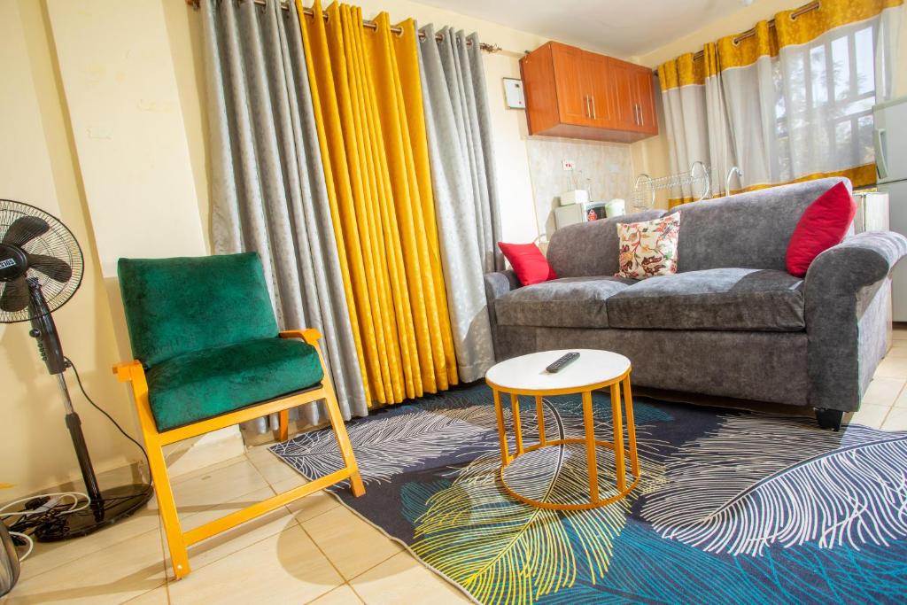 基苏木Tom Mboya Estate - Fast WI-FI, Netflix and Parking 1Br Apartment in Kisumu Town的客厅配有沙发和椅子