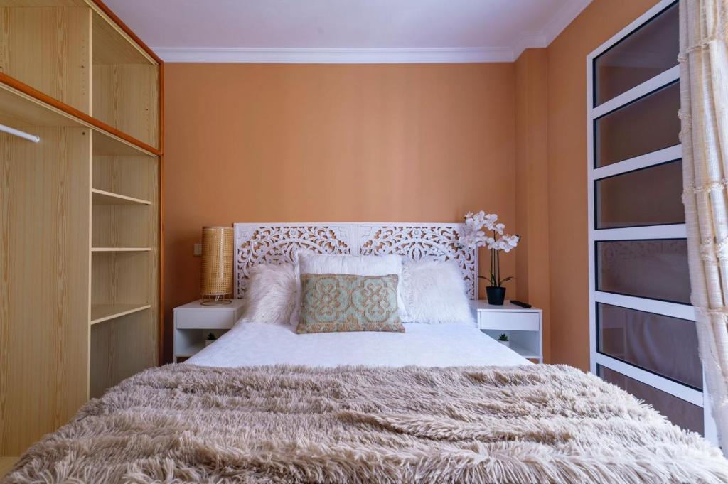 拉加里塔La Garita Vista azul的一间卧室设有一张大床和一个窗户。