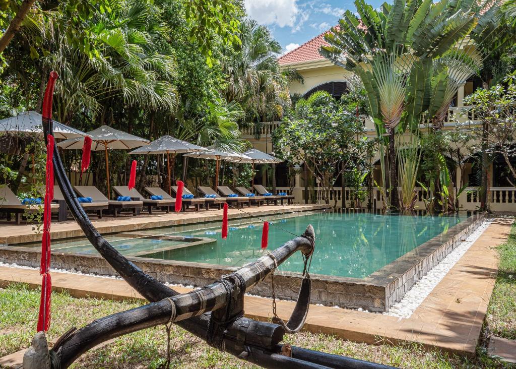 暹粒Pavillon d'Orient Boutique Hotel的一个带椅子的游泳池,一个度假胜地