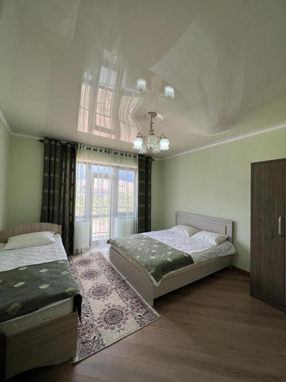 博斯特里Гостевой дом RAZAM的一间卧室设有两张床和窗户。