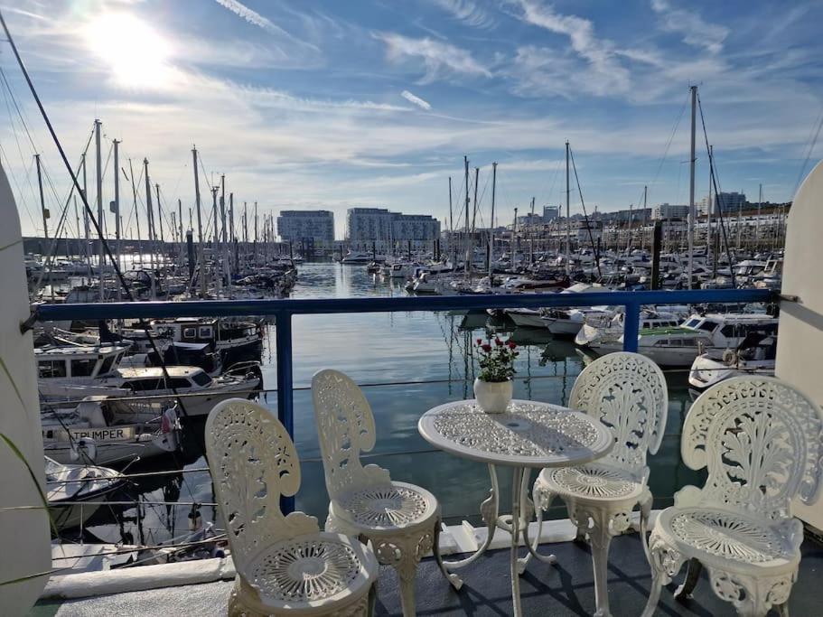 布莱顿霍夫Sea Breeze in Brighton Marina with Free Parking的一个带码头的阳台,配有桌椅