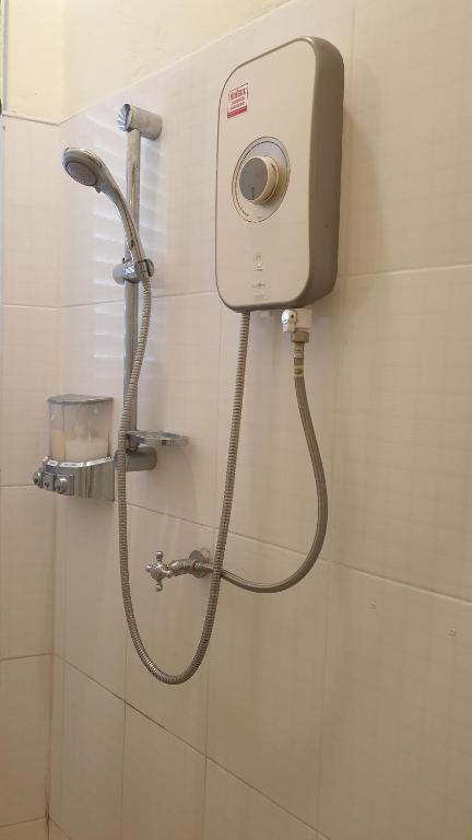 董里Thunyaporn Hostel的浴室里设有淋浴,墙上装有水管