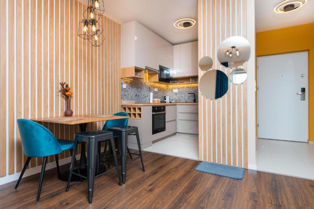 布达佩斯WaterFront City Apartments by UrbanRent的厨房配有木桌和蓝色椅子