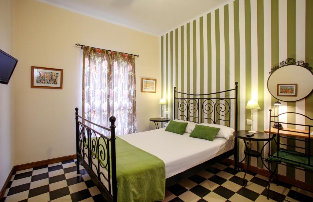 马拉加马拉加住宿加早餐旅馆的一间卧室配有一张床、镜子和窗户