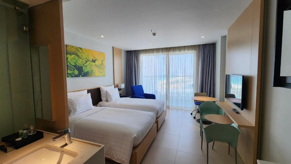 金兰市Home Seview at Cam ranh Nha Trang Aparment的酒店客房设有两张床和电视。