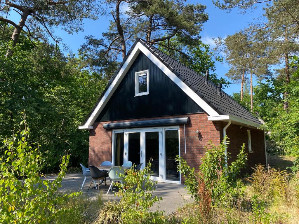 宁斯佩特Luxe Vakantiehuis Vosje op de Veluwe Nunspeet的黑色屋顶的红砖小房子
