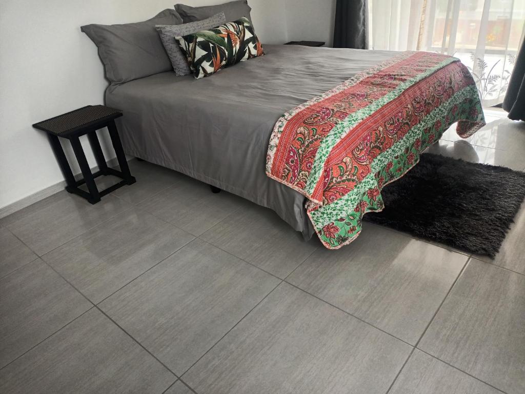KingsboroughLotus Accommodation的卧室配有1张床,铺有瓷砖地板。