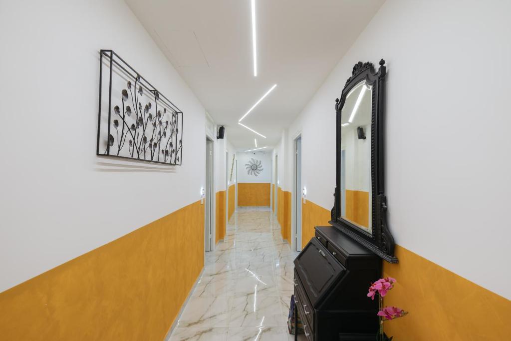 圣雷莫AFFITTACAMERE ELENA的走廊上设有橙色和白色的墙壁和镜子