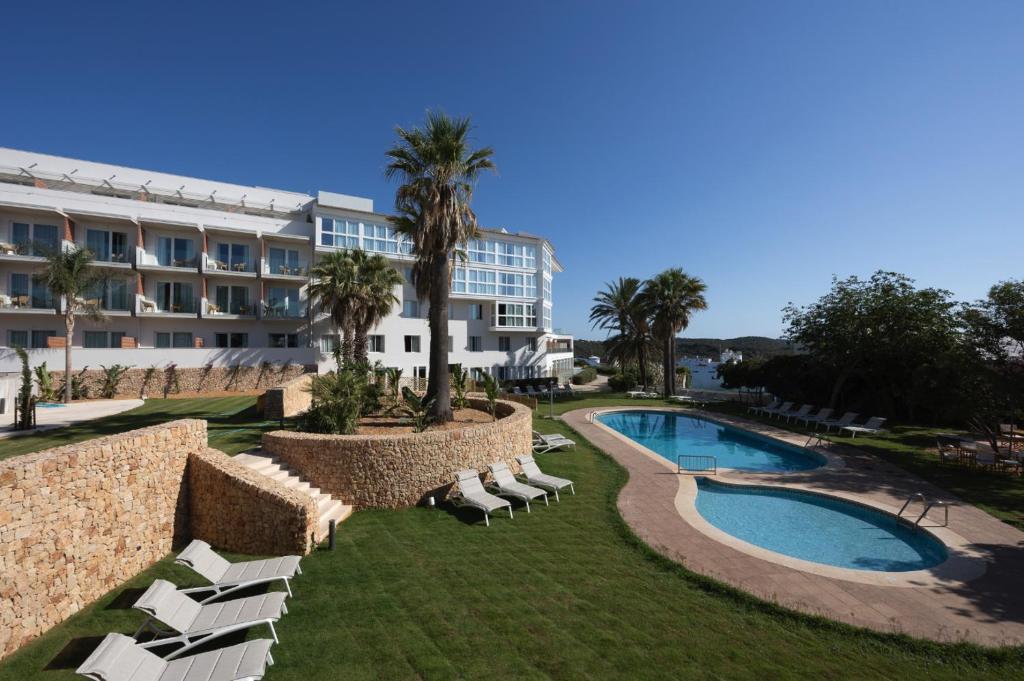 马翁加泰罗尼亚港瞭望台酒店的一座带游泳池和躺椅的度假村和一座建筑