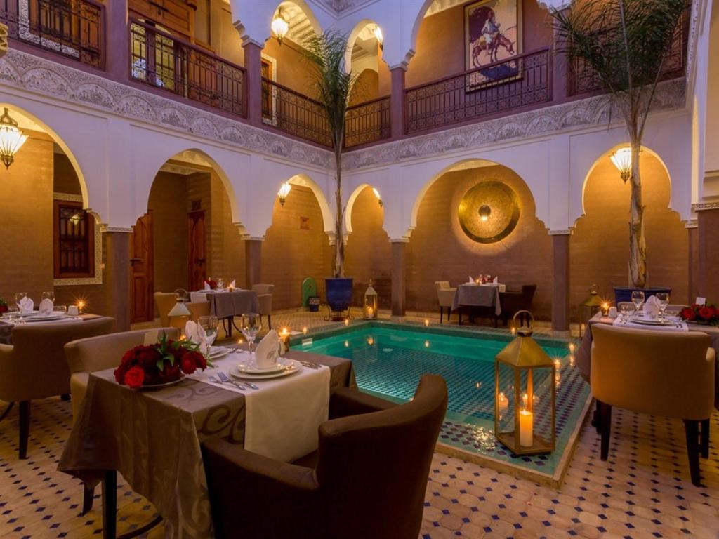 马拉喀什玛格达及Spa传统庭院住宅的大楼中间带游泳池的餐厅