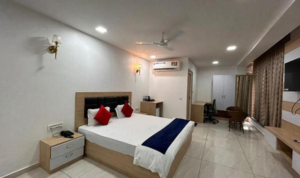 海得拉巴FabHotel Prime Anika Suites的一间卧室配有一张带红色枕头的大床