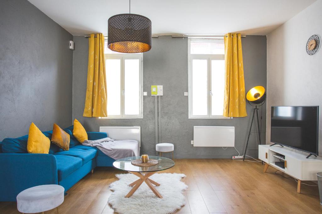 图尔昆Colocation de luxe à Tourcoing avec jardin的客厅配有蓝色的沙发和电视
