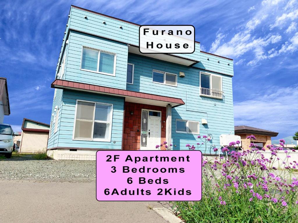 富良野Furano House, JR Station, 2F Apartment, 3 Bedrooms, Max 8PP - 6 Adults 2 Kid, Onsite Parking的蓝色房子前面有标志
