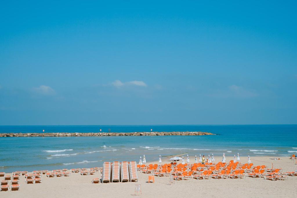 巴特亚姆Roxon Sea Sand Bat Yam的海滩上设有椅子和遮阳伞,还有大海