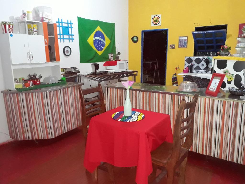 劳鲁-迪弗雷塔斯Perto Do Aeroporto De Salvador - Dona Pitanga Hostel的厨房配有一张带红色桌布的桌子
