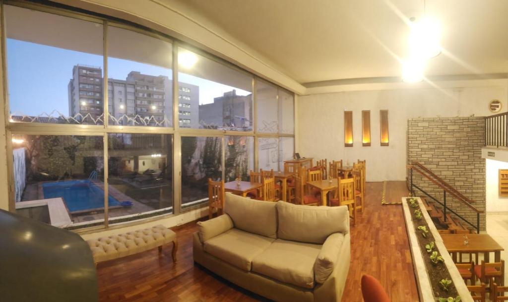萨尔塔Pachá Hostel Backpack的带沙发和大窗户的客厅