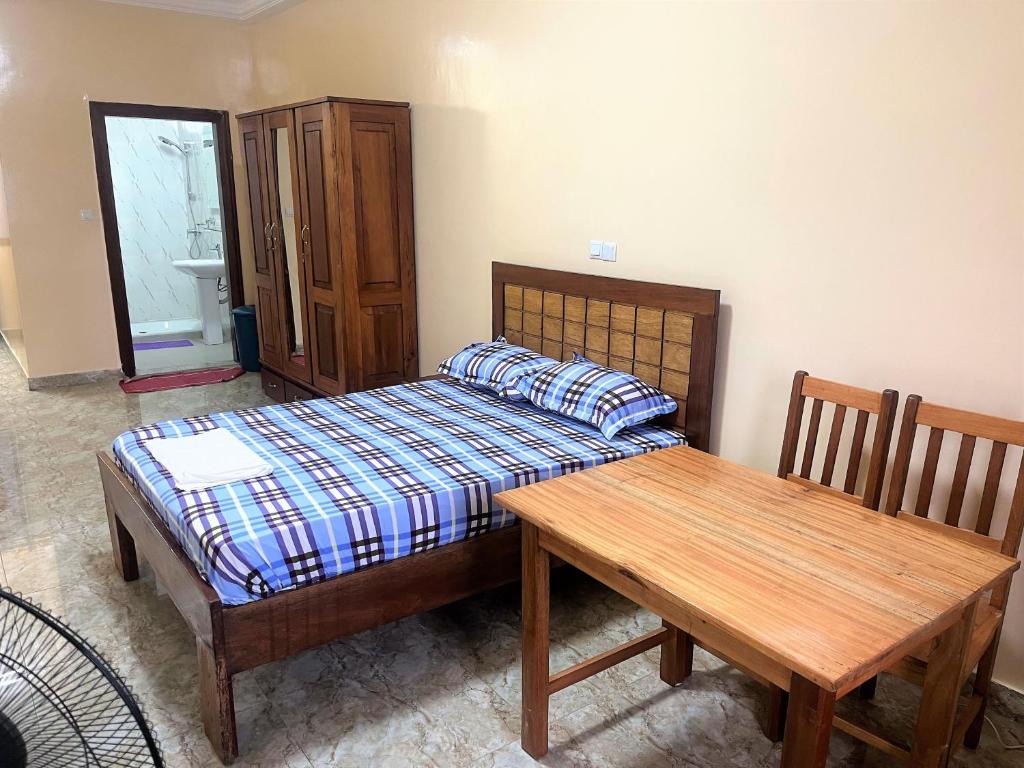 达喀尔CHAMBRES PRIVEE-APPARTEMENT VUE SUR MER的一间卧室配有一张床和一张木桌