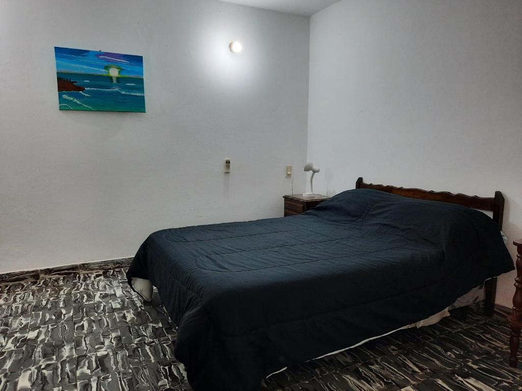 科连特斯DEPARTAMENTO COSTA PLANTA ALTA的卧室配有一张床,墙上挂有绘画作品