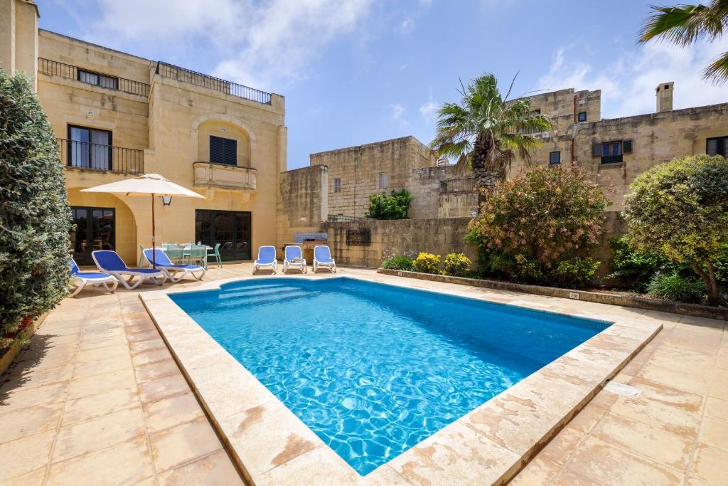 加斯利Dar ta' Lonza Villa with Private Pool的一座建筑的庭院中的游泳池