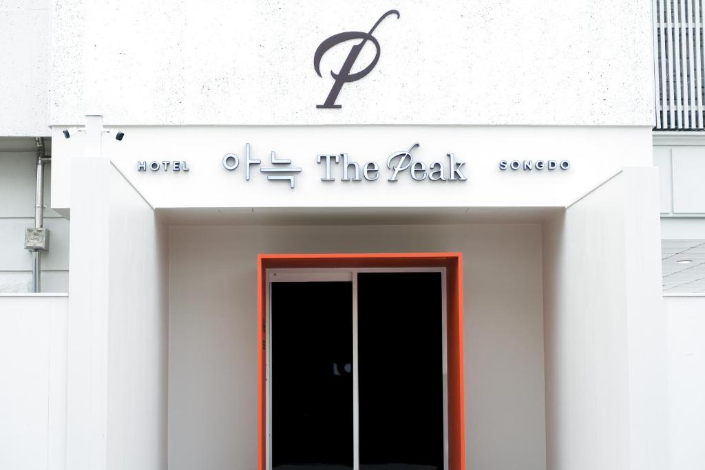 仁川市Aank Thepeak Hotel Incheon Songdo的建筑前有门的标志