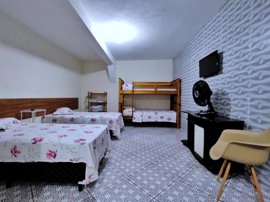瓜鲁柳斯Pousada Guarulhos的一间酒店客房,设有两张床和电视
