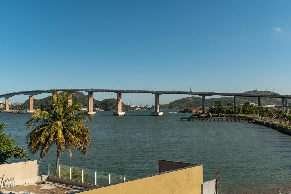 维多利亚Casa 4 Suítes - Ilha do Boi的河上一座桥,前方有棕榈树