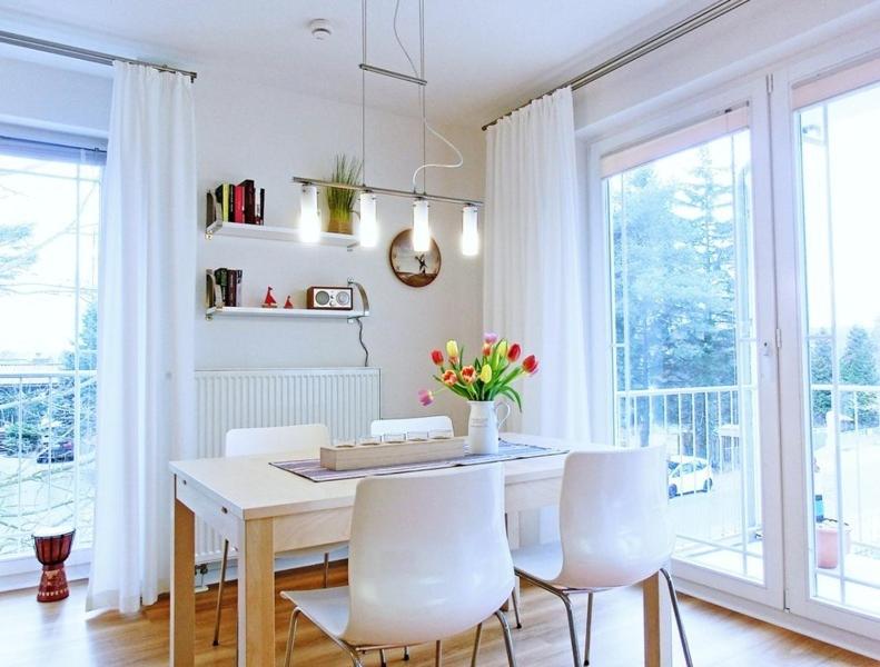赛巴特班森Strandoase - FeWo 21的一间带桌子和白色椅子的用餐室