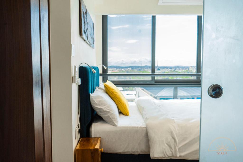 阿克拉SOLEA - Super central, comfortable and modern apartment的一间卧室设有一张床和一个大窗户