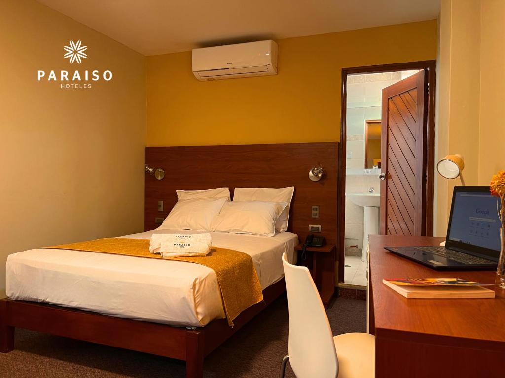 齐克拉约Hoteles Paraiso CHICLAYO的一间卧室配有一张床和一张带笔记本电脑的书桌