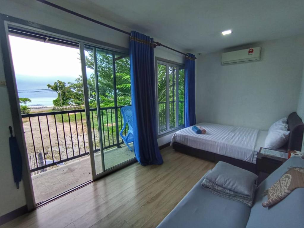 马六甲乐图度假屋的一间卧室配有一张床,享有海景