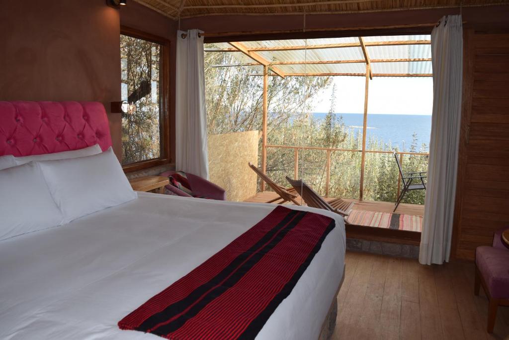 奥科苏尤Allpaluxe Peru Lodge的一间卧室配有一张床,享有海景