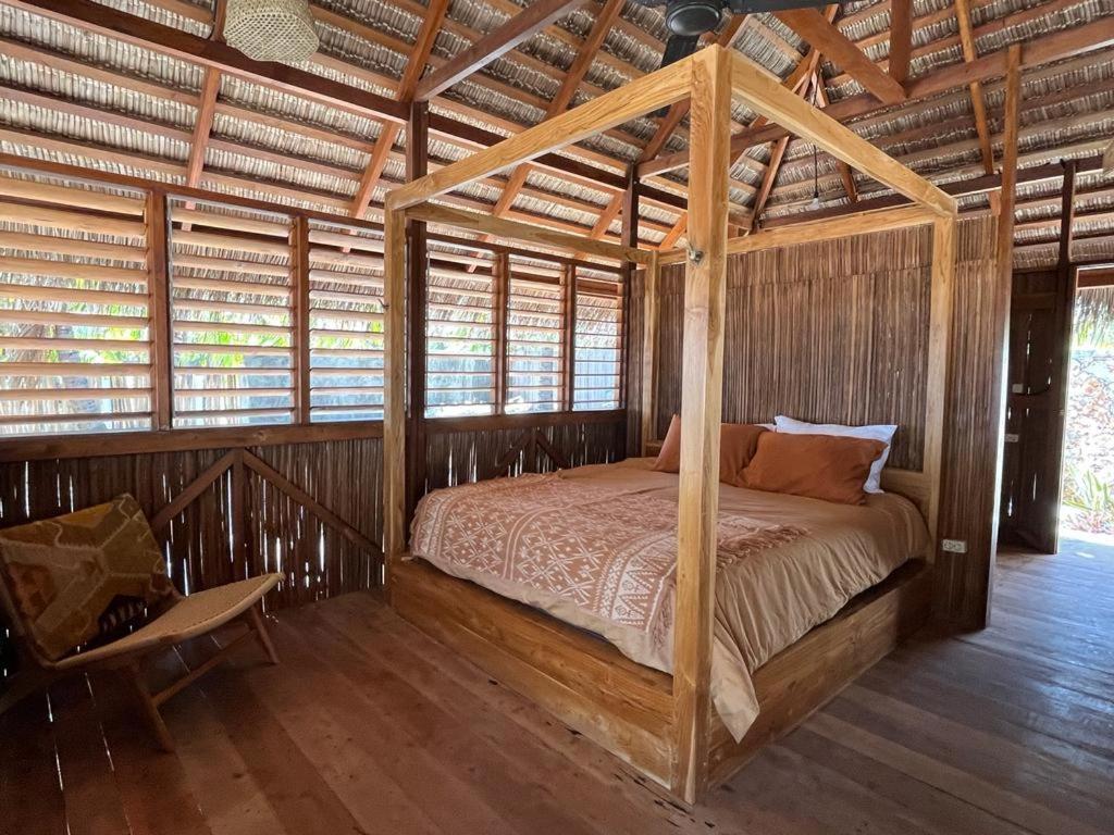 内布拉拉VILLA LANGIT TEDUH ROTE的木屋内的卧室配有天蓬床