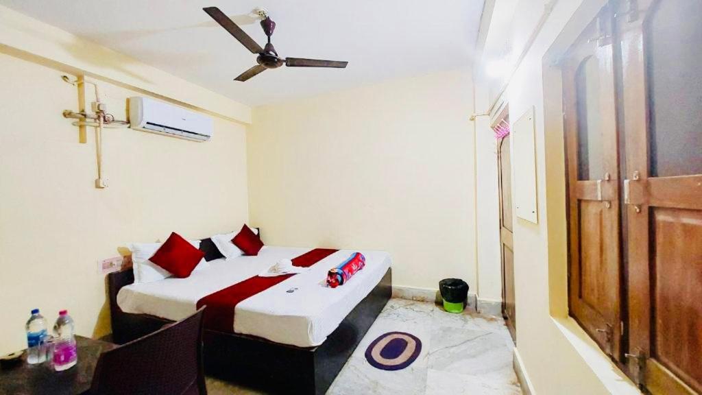 普里Hotel Ashok Royal ! Puri的一间卧室配有两张床和吊扇
