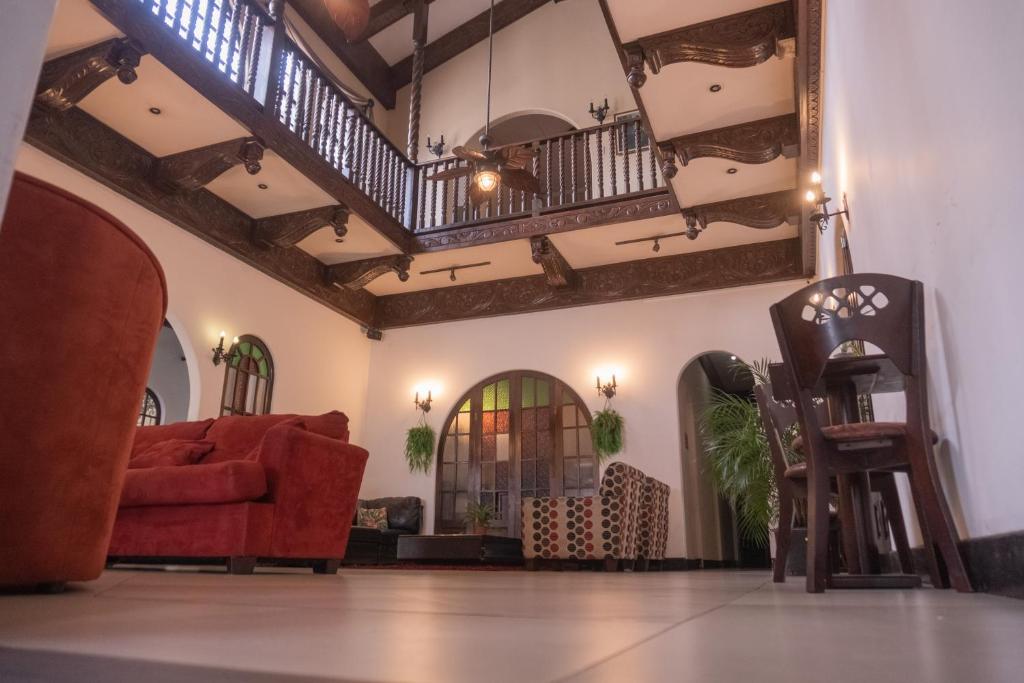 圣何塞卡萨克隆旅馆的客厅配有红色的沙发和椅子