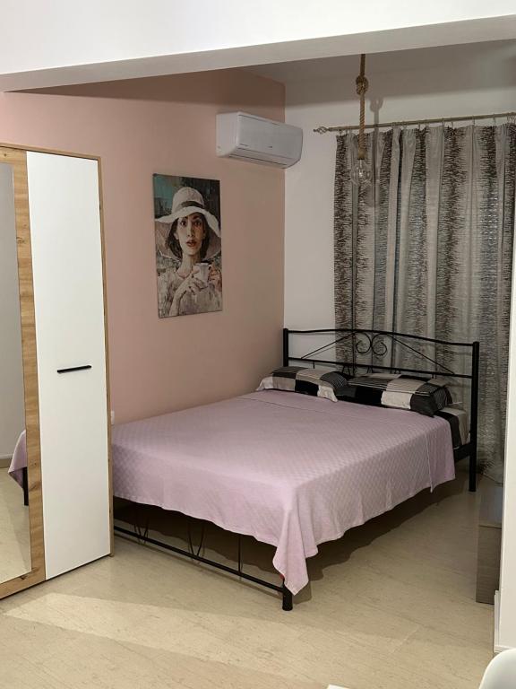 依拉佩特拉SeaSideRooms的卧室配有一张床和一张女人的照片