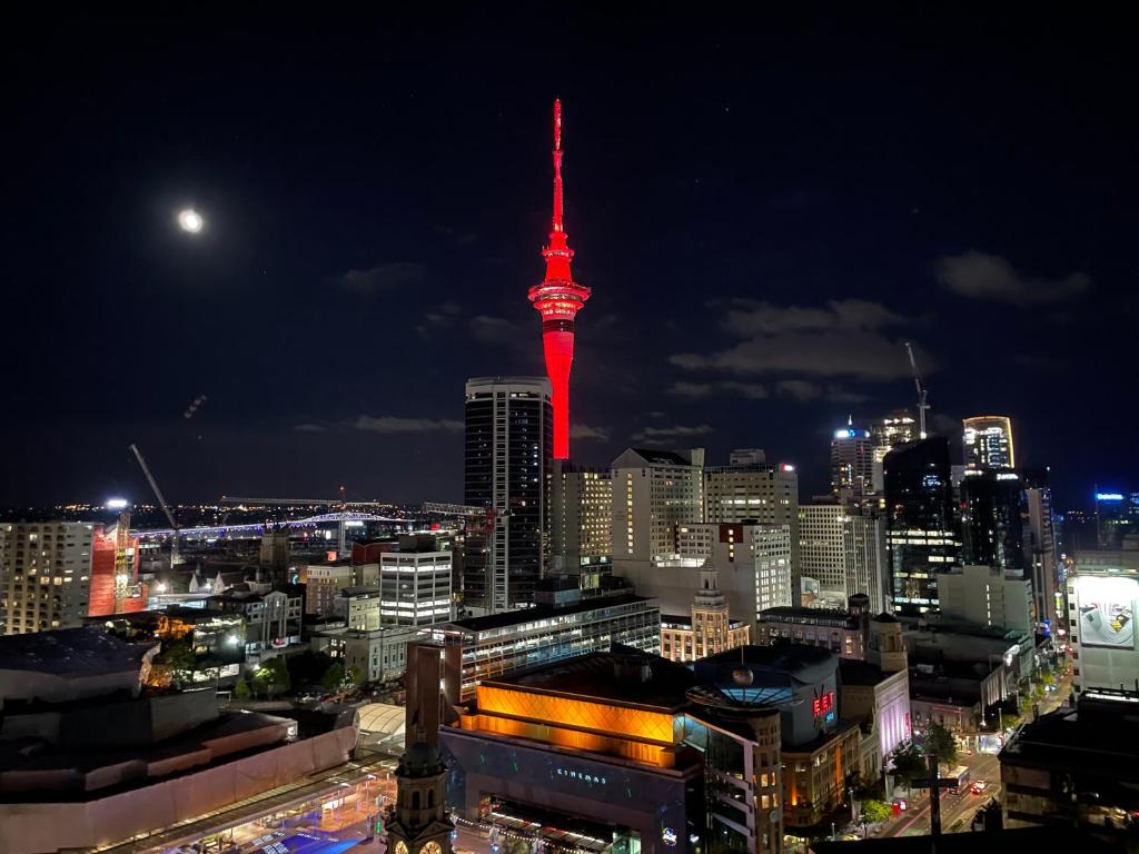 奥克兰Apartment with Brilliant views in Auckland CBD的享有红色塔楼夜间城市美景