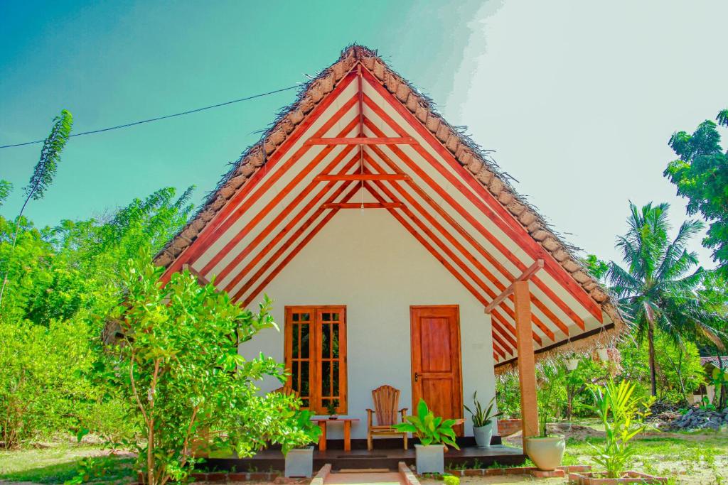 锡吉里亚Sigiri Enaya Cottage的茅草屋顶的小房子