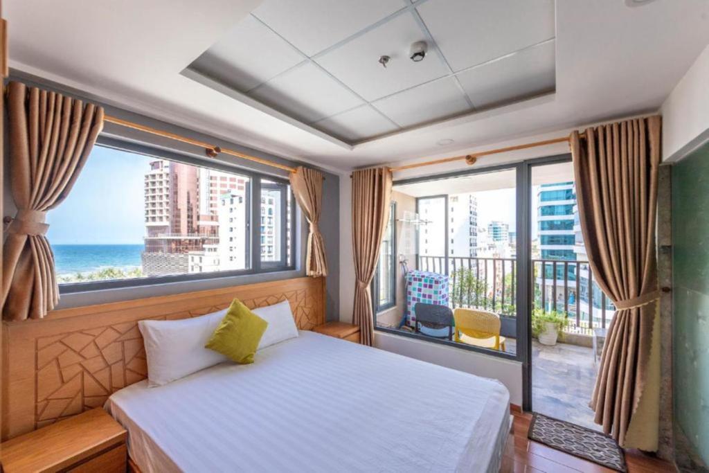 岘港Taian Hotel & Apartment的卧室设有海景大窗户