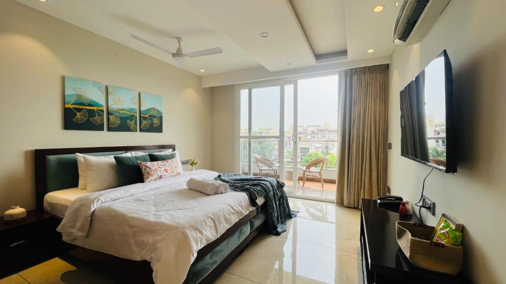 古尔冈ZEN Suites Gurgaon - LUXE Stays Collection的一间卧室设有一张大床和一个大窗户