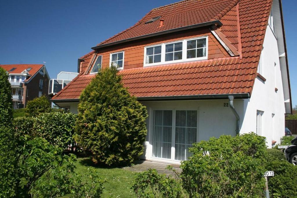 多鲁姆Ferienwohnung Wohlfühldomizil的一座带橙色屋顶和灌木的房子
