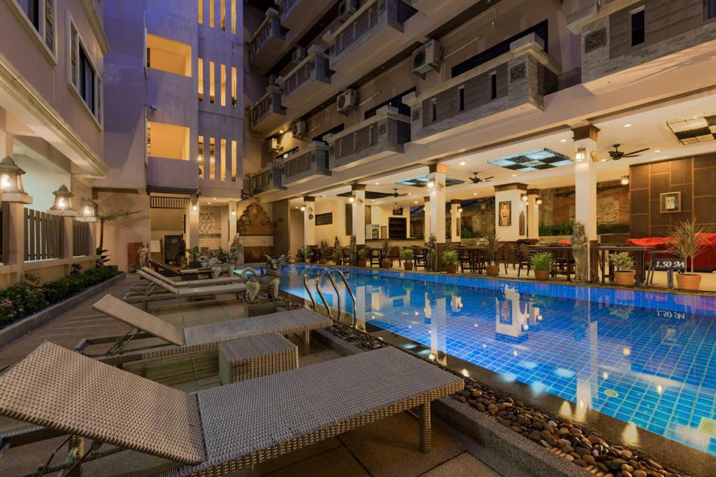 芭东海滩塞卡精品度假酒店的一座带桌椅的大型游泳池