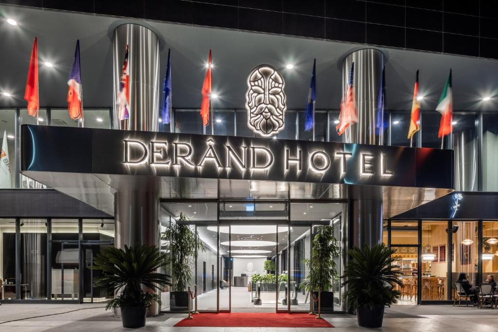 普里什蒂纳Derand Hotel的夜间大酒店入口的 ⁇ 染