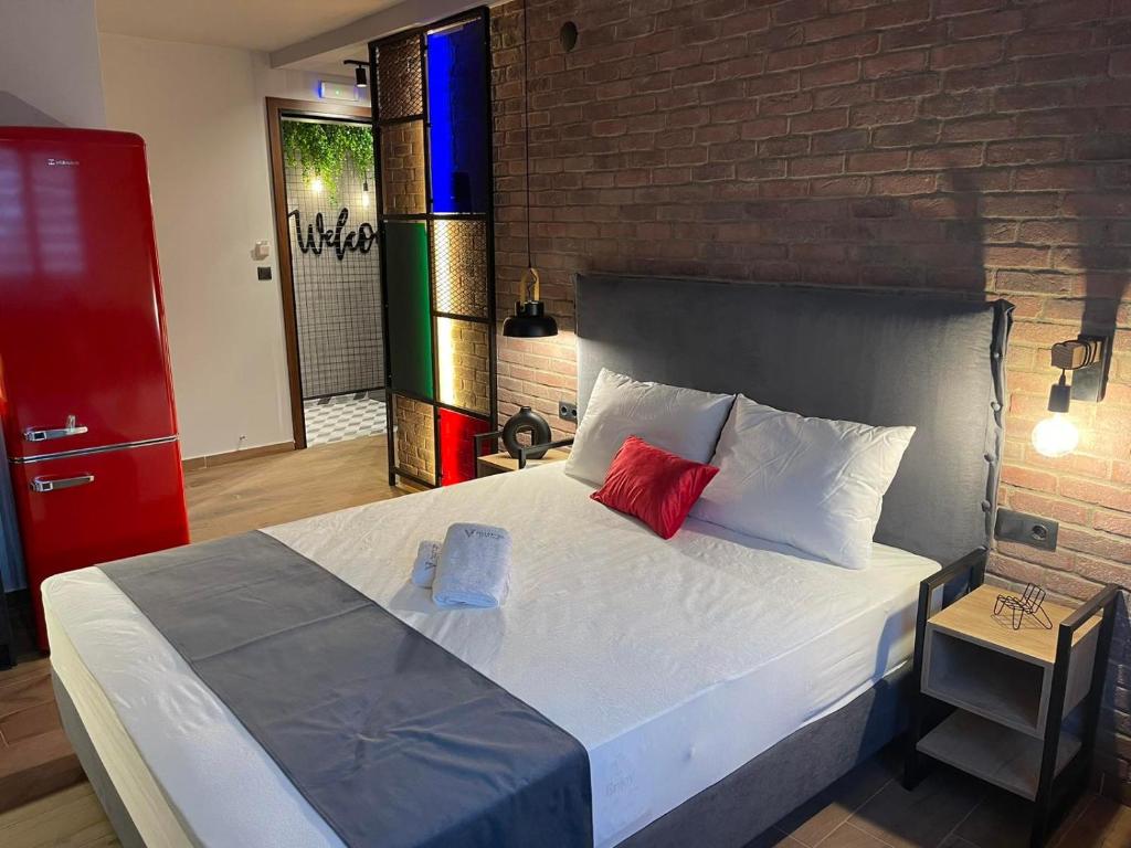 塞萨洛尼基Valaoritou 3 Luxury Rooms的一间卧室设有一张带砖墙的大床