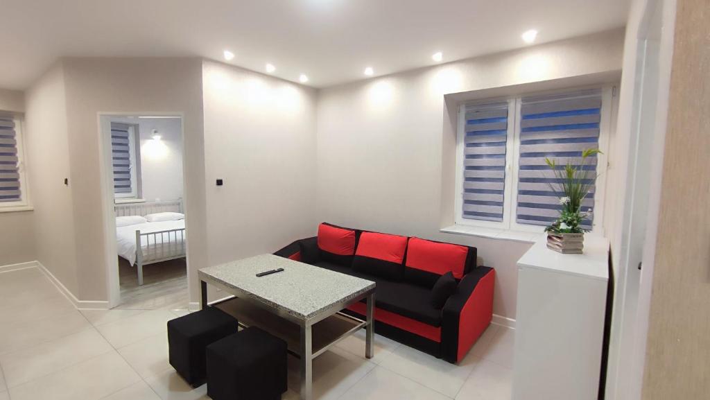佩霍维采Apartamenty Tuwima的客厅配有红色的沙发和桌子