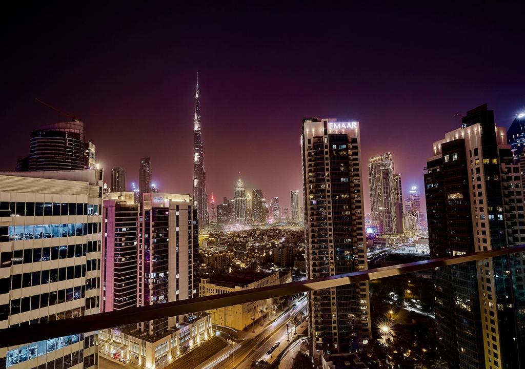 迪拜Luxury Studios with Burj Khalifa or Canal View in Downtown - Marquise Square Tower的享有夜间城市景观和建筑