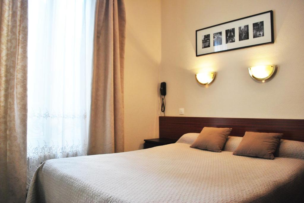 巴黎艾文莉容基耶尔酒店的一间卧室配有带两个枕头的床和窗户