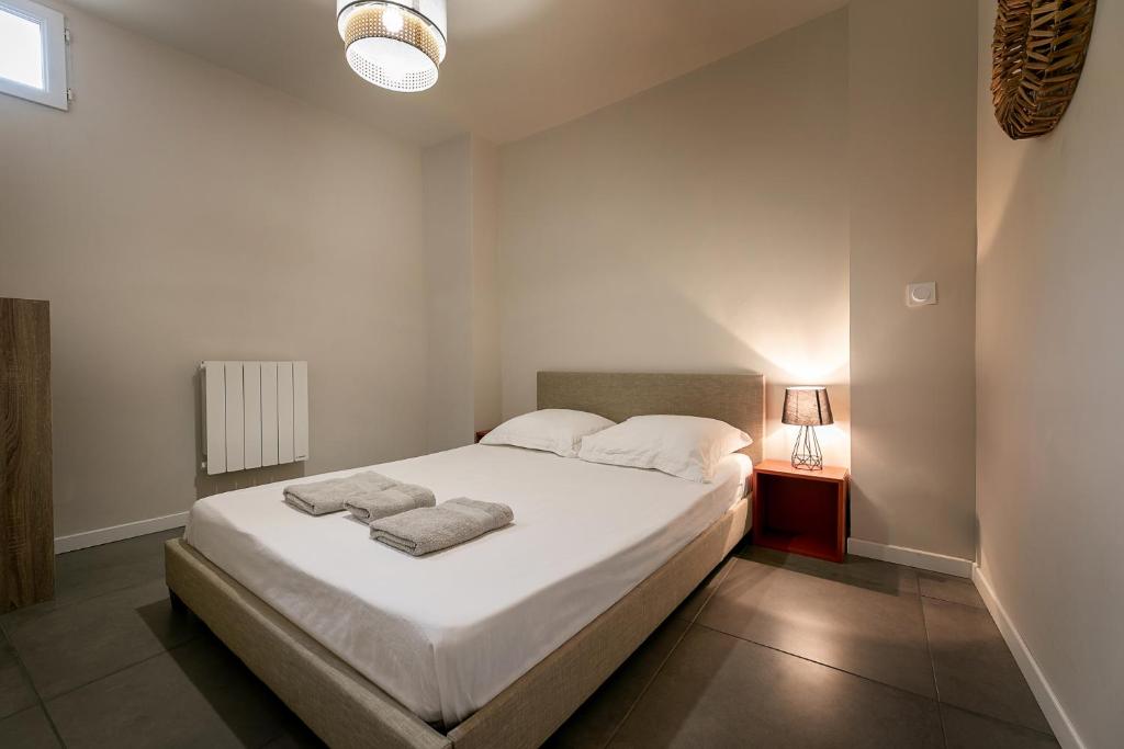 佩皮尼昂Perpignan - Appartement en centre ville的卧室配有白色的床和2条毛巾