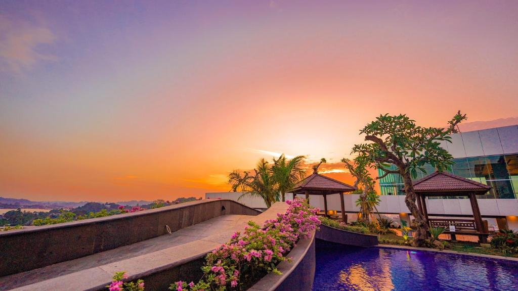 沙马林达FUGO Hotel Samarinda的度假村游泳池的日落