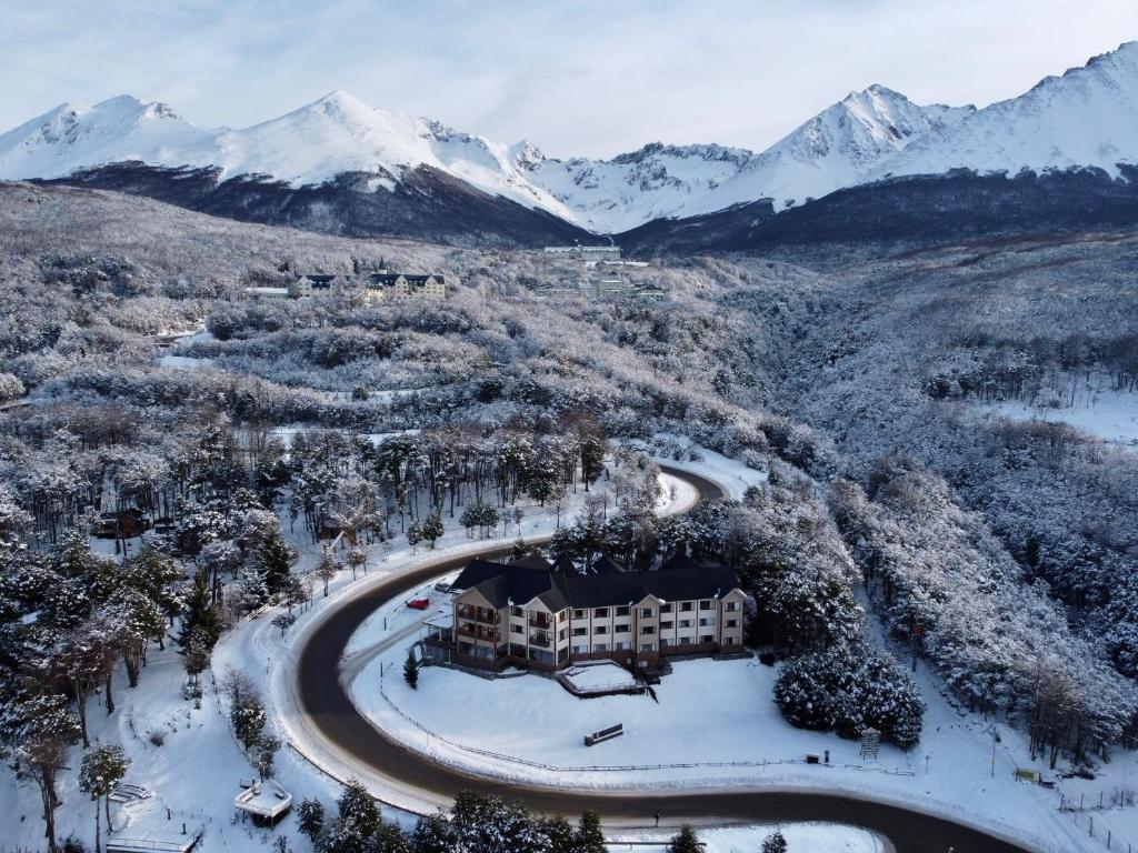 乌斯怀亚Altos Ushuaia Hotel & Resto的享有度假胜地的空中景致,该度假胜地拥有雪覆盖的山脉